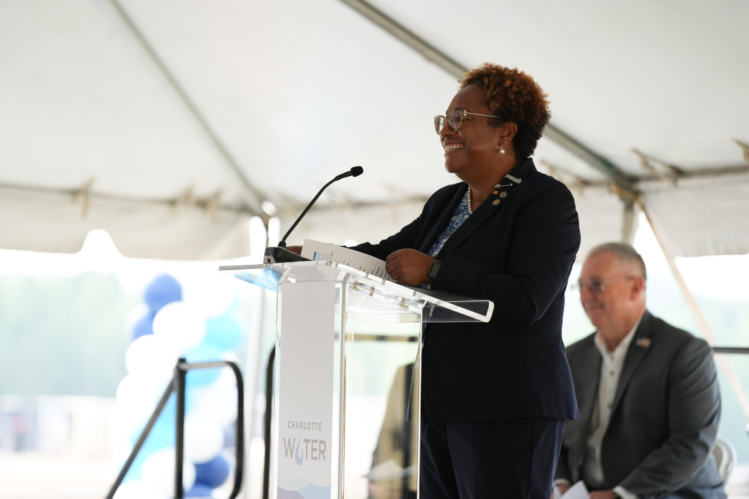 Angela Charles smiles at the crowd from the Charlotte Water podium.