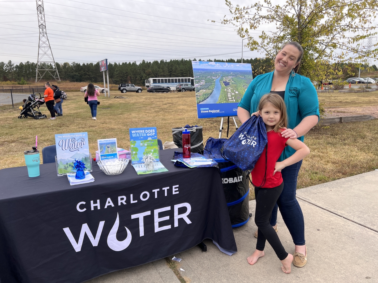 Nicole Bartlett and her daughter stand at a Charlotte Water table at a local school.
