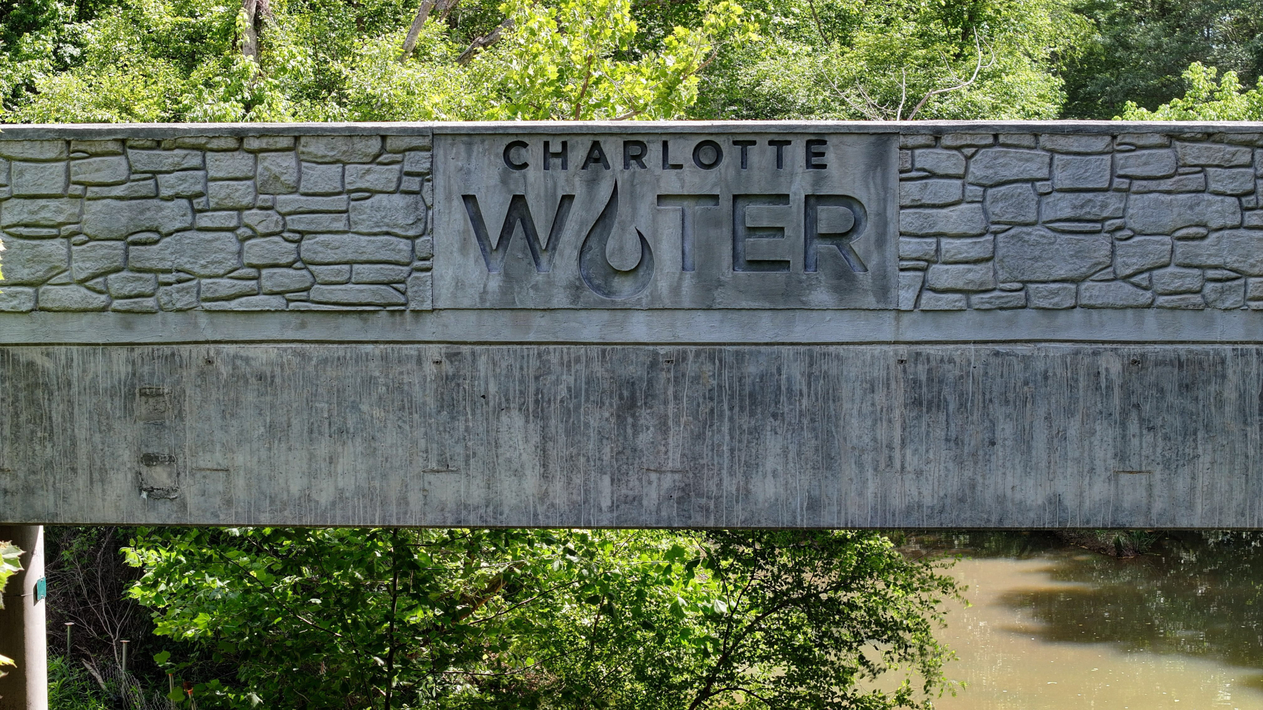 Charlotte Water logo in the concrete of a bridge.