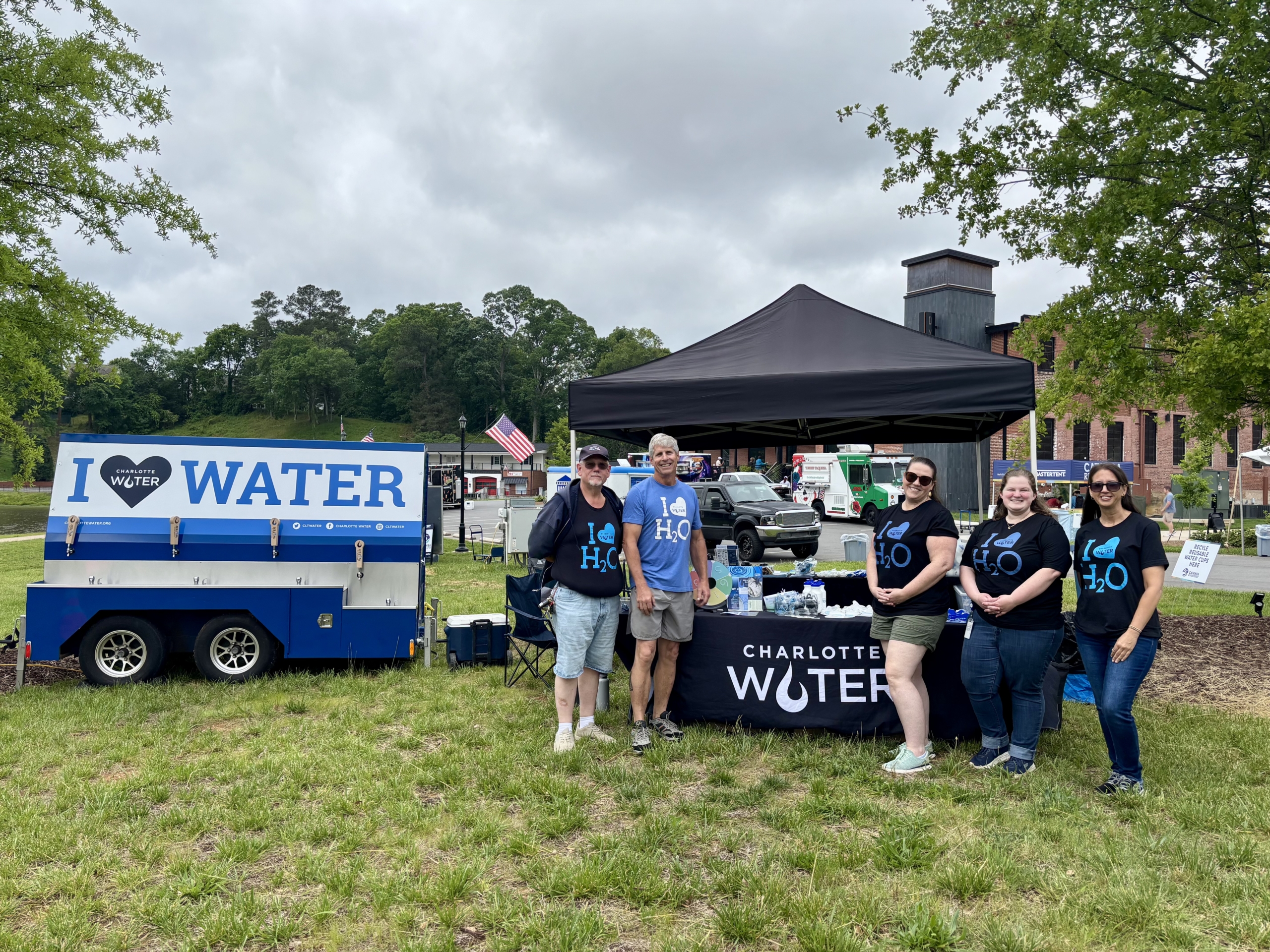 Charlotte Water staff in front of a tent and water wagon