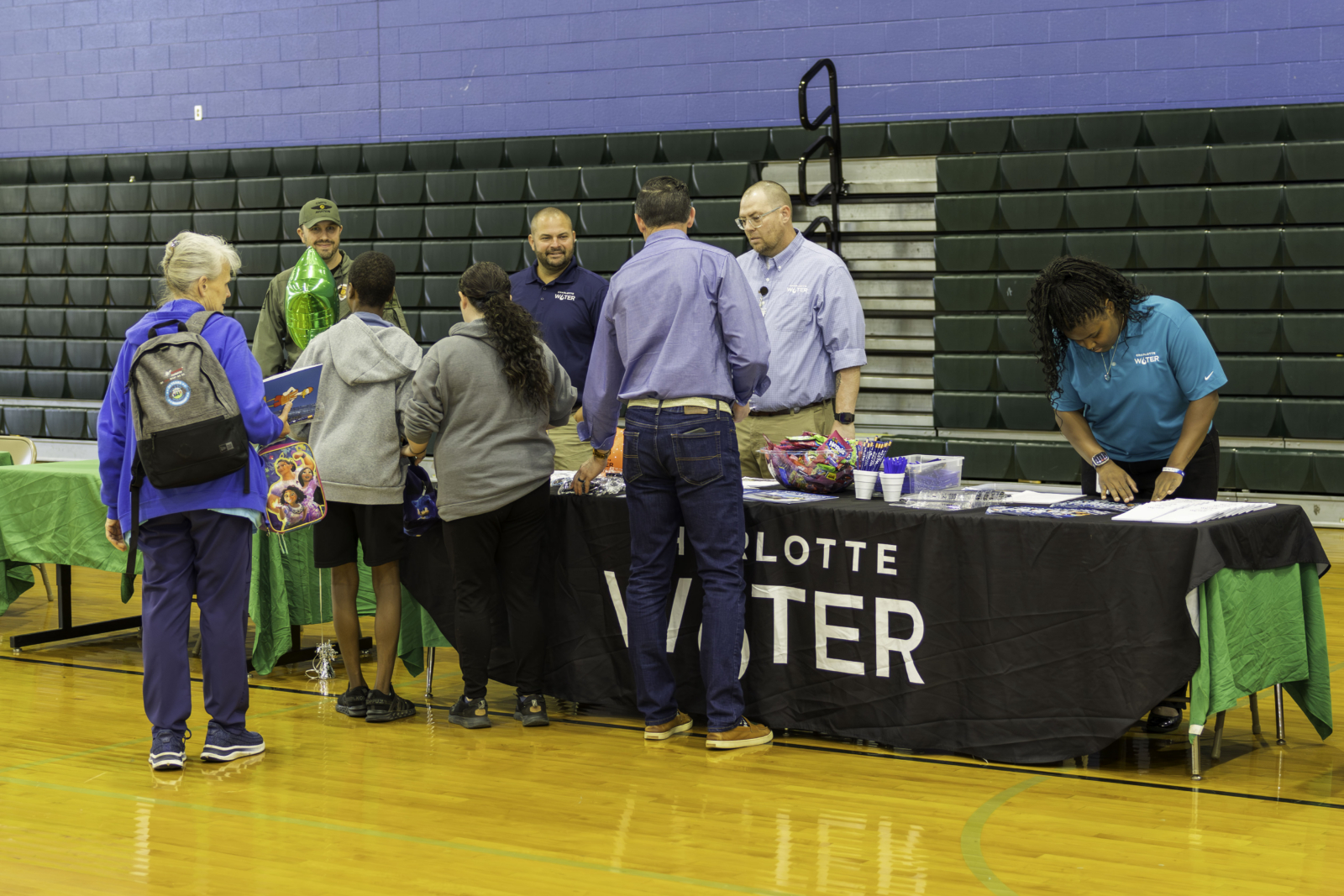 Students gather around a Charlotte Water table to talk to employees