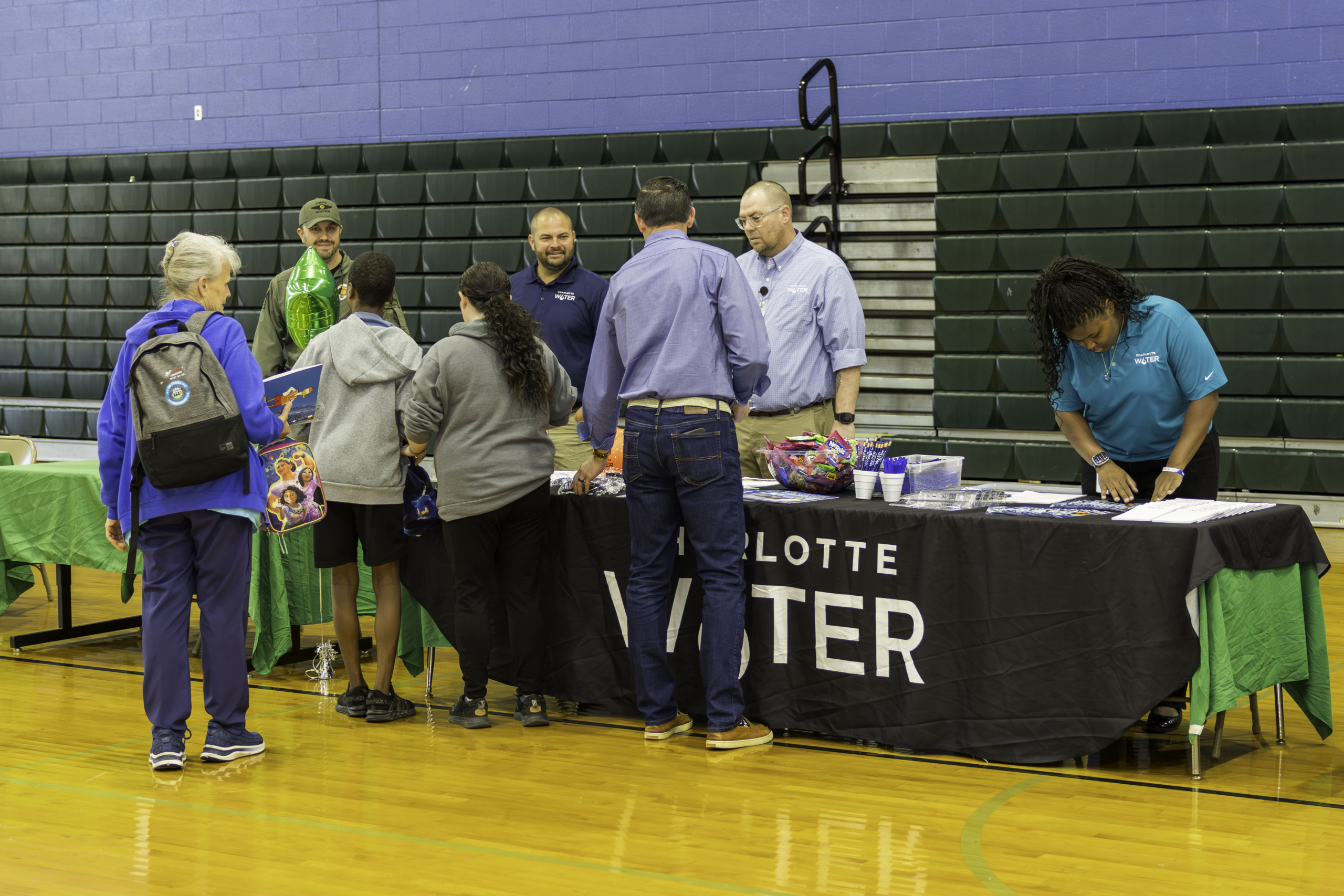 Students gather around a Charlotte Water table to talk to employees