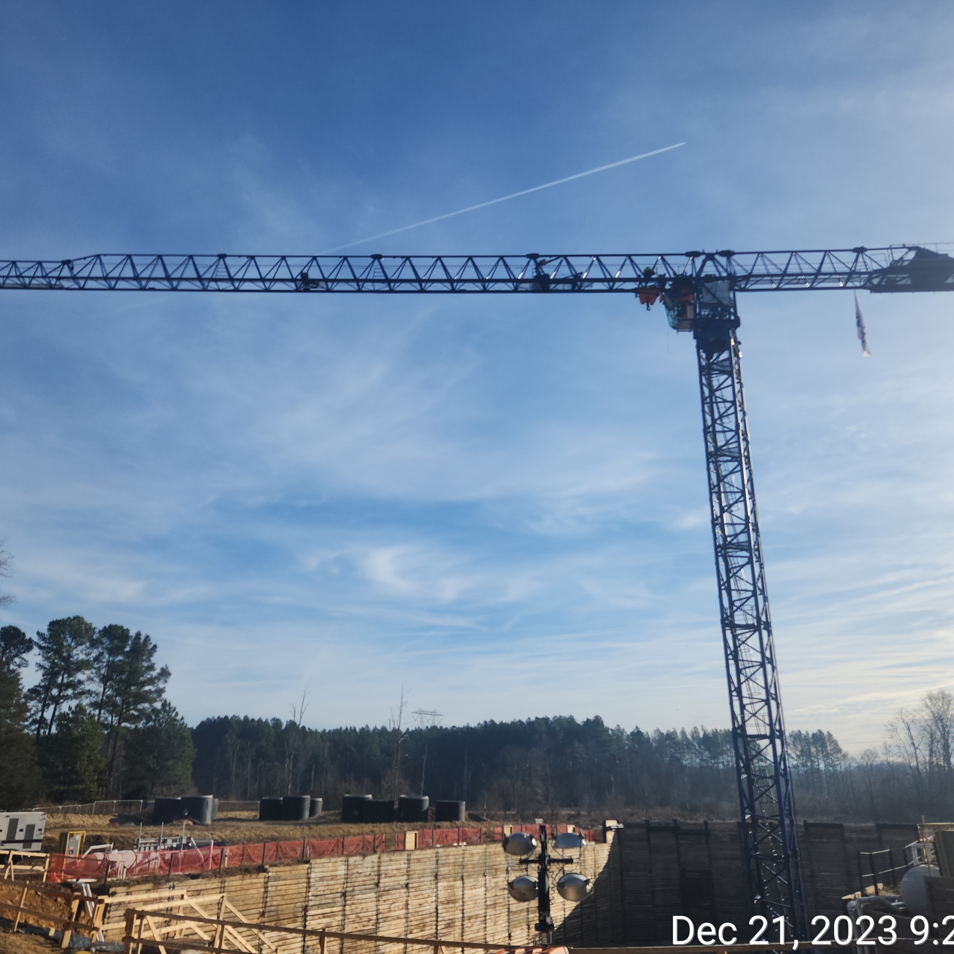 L shaped tower crane over a construction site with blue skies