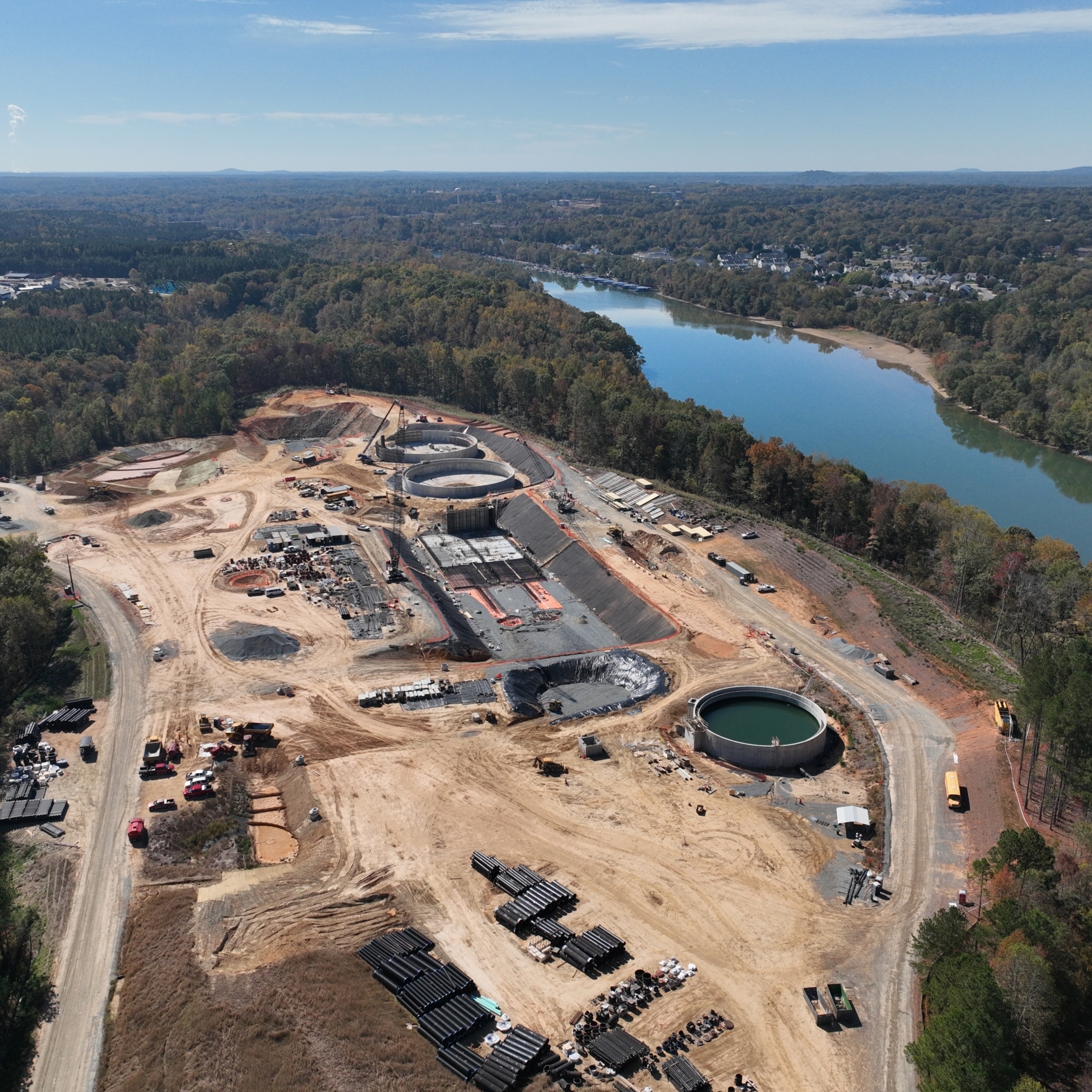 aerial drone photograph of a construction site surrounded by trees next to the Catawba River