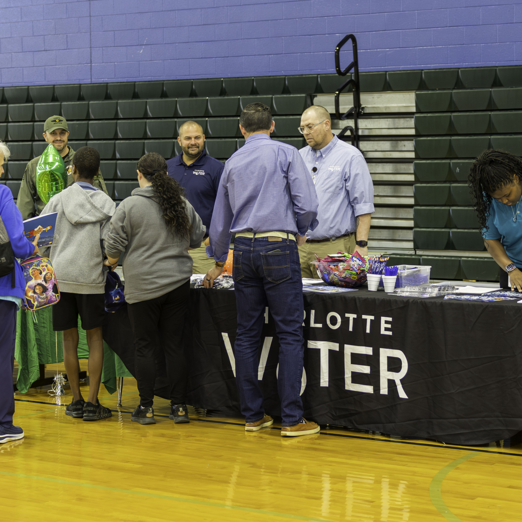 Students gather around a Charlotte Water table to talk to employees
