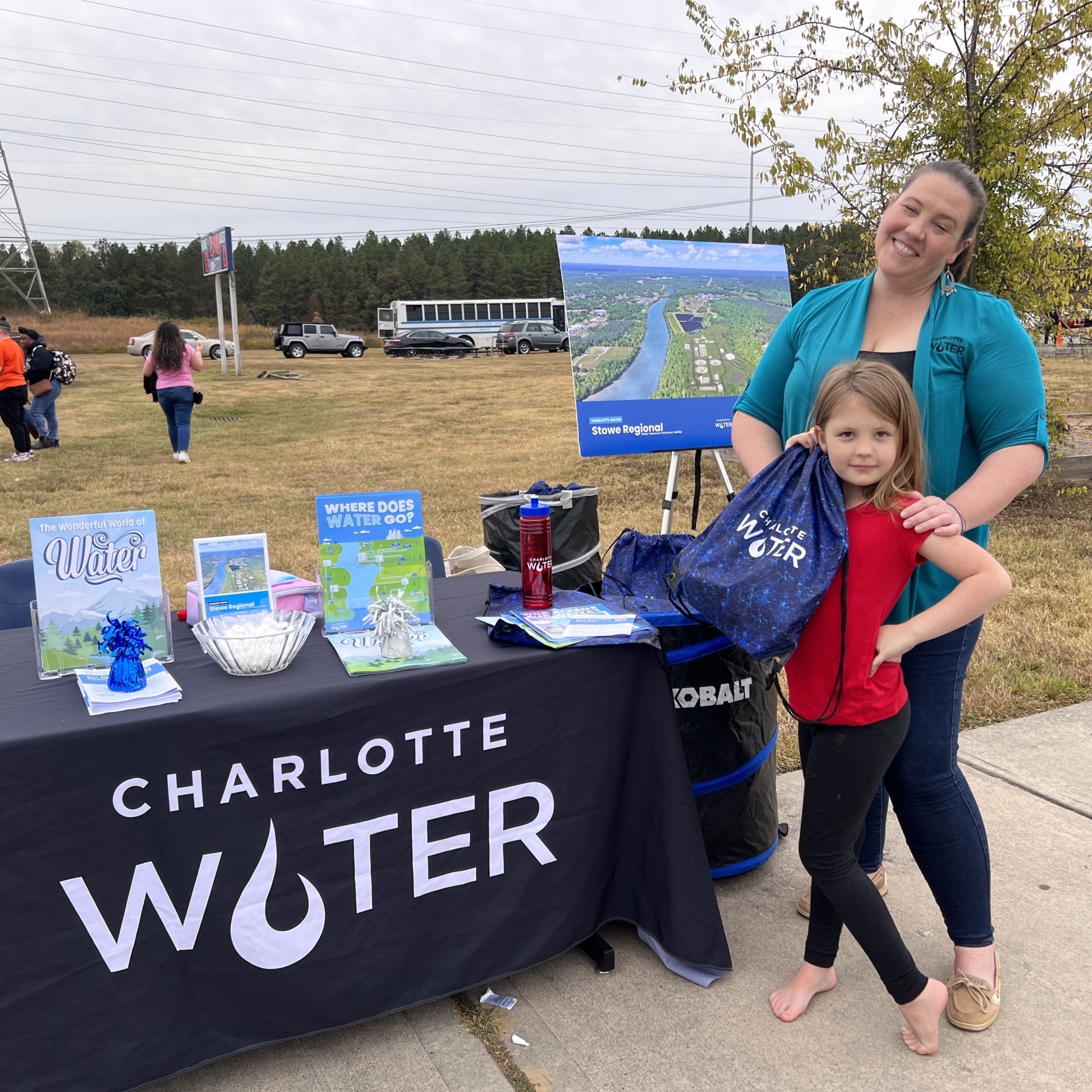 Nicole Bartlett and her daughter stand at a Charlotte Water table at a local school.